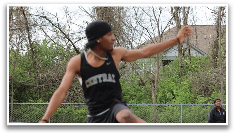 A man in a black shirt and black shorts is jumping in the air. Description generated by AI