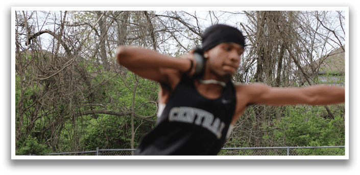 A man wearing a black shirt and a white hat is stretching his arms out. Description generated by AI