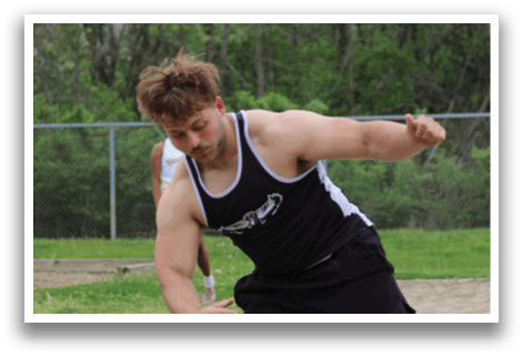 A man wearing a black and white shirt is throwing a disc. Description generated by AI