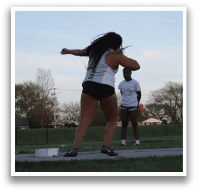 Two people playing frisbee in a field. Description generated by AI