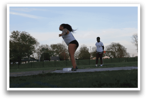 Two people playing frisbee in a field. Description generated by AI