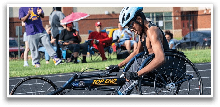A man in a wheelchair is racing on a track. Description generated by AI