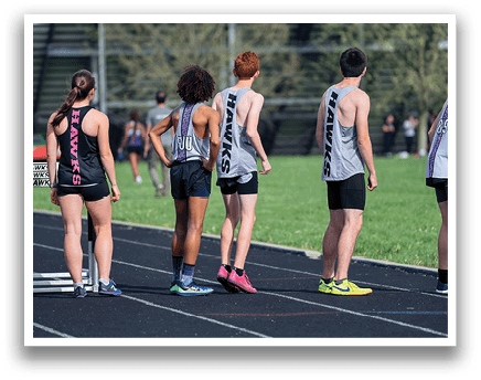 A group of people wearing black and grey shirts and shorts are standing on a track. Description generated by AI