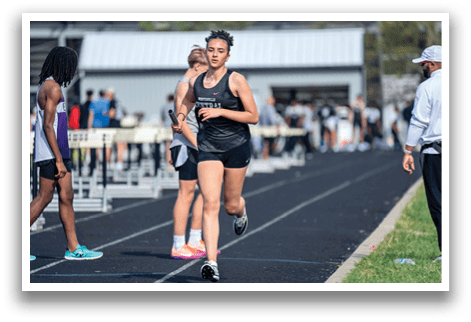 A woman running on a track. Description generated by AI