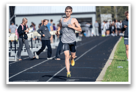 A man running on a track. Description generated by AI