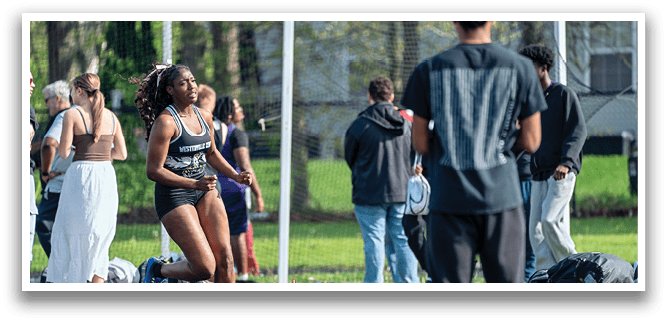 A woman running on a track with a pink water bottle. Description generated by AI