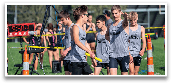 A group of young men wearing grey shirts and black shorts. Description generated by AI