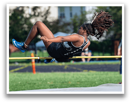A man is jumping over a barrier. Description generated by AI