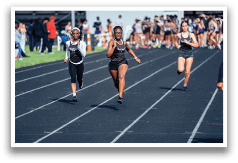 A group of girls running on a track. Description generated by AI