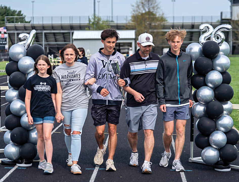 A group of people walking on a track. Description generated by AI