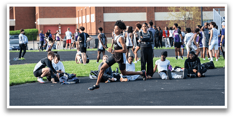 A group of people are sitting on the ground in a field. Description generated by AI