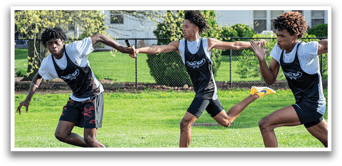 Two boys running on a track. Description generated by AI