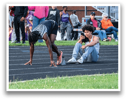 A man is kneeling on a track. Description generated by AI