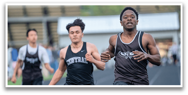 Two boys running on a track. Description generated by AI