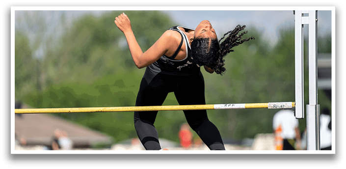 A woman is jumping over a barrier. Description generated by AI