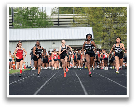 A group of people running on a track. Description generated by AI