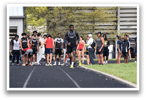 A group of people are running on a track. Description generated by AI