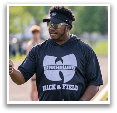 A man wearing a black and white shirt with the word Warhawks on it. Description generated by AI