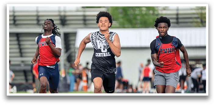 Three young men running on a track. Description generated by AI