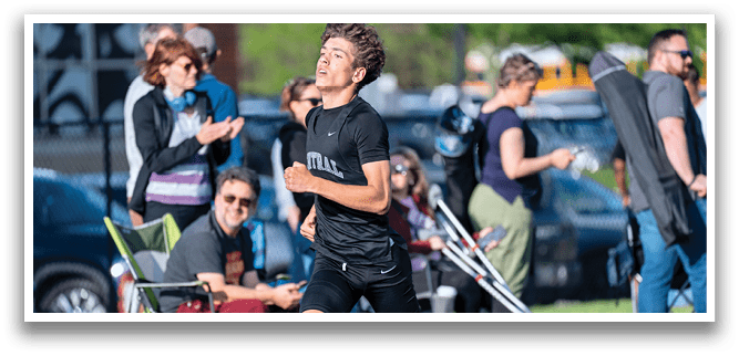 A man running on a track. Description generated by AI