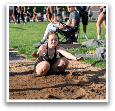 Two women running on a track. Description generated by AI