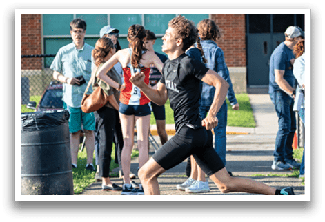 A man running on a track. Description generated by AI