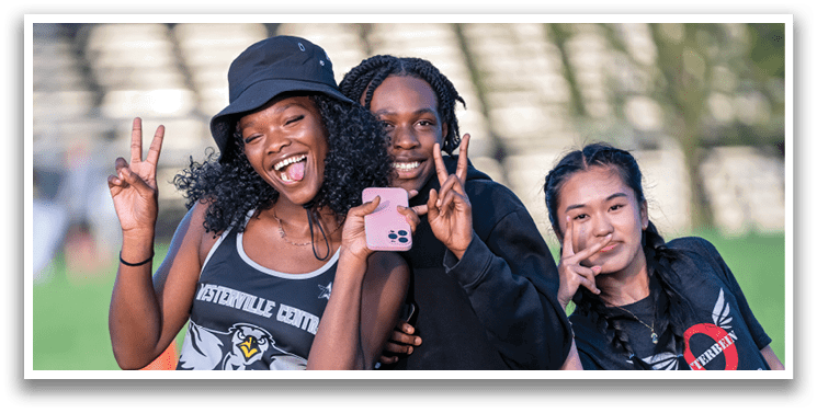 Three girls are posing for a picture. Description generated by AI