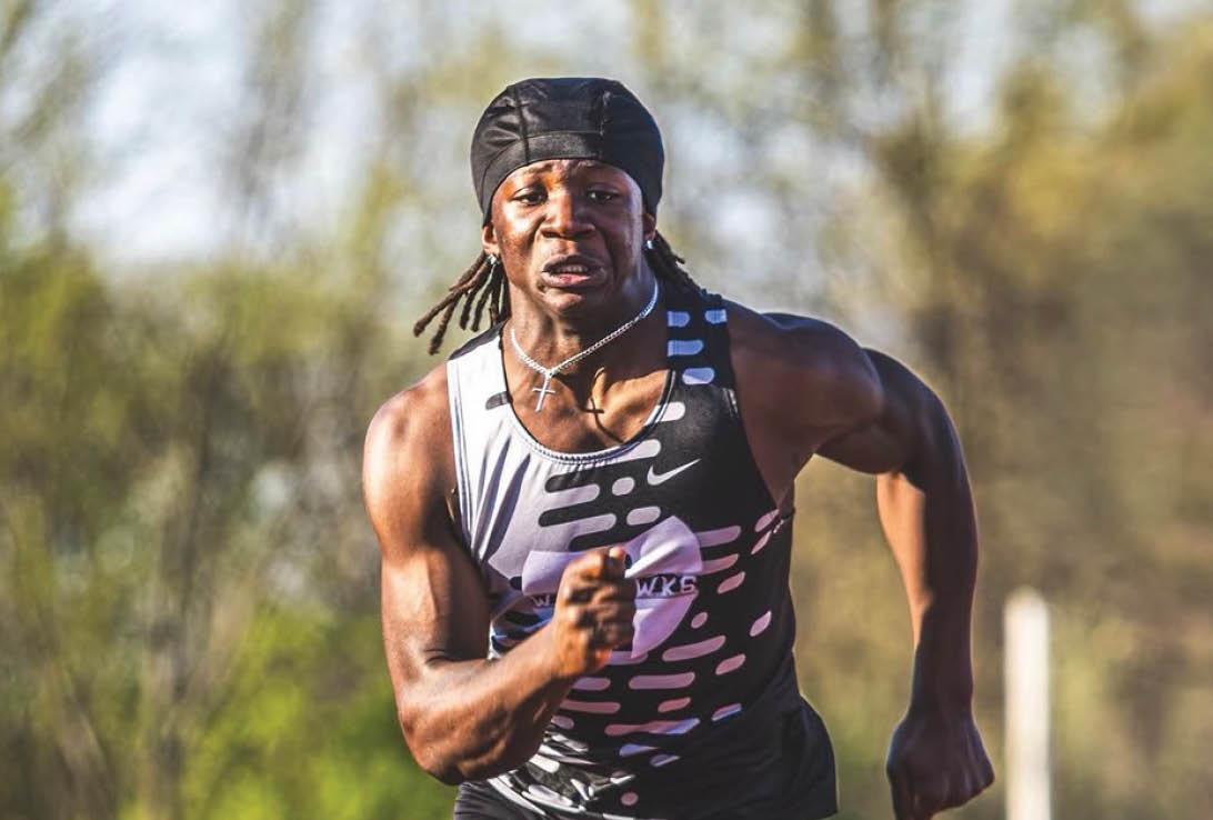 A man running on a track. Description generated by AI