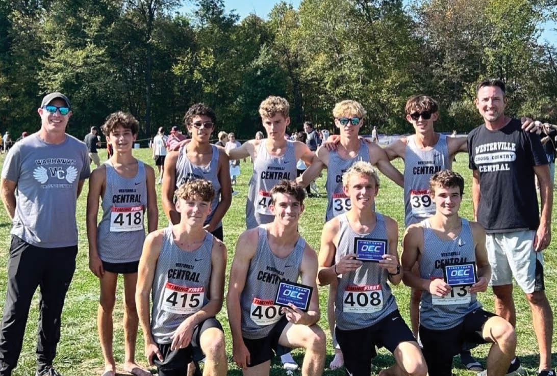 A group of runners posing for a photo. Description generated by AI