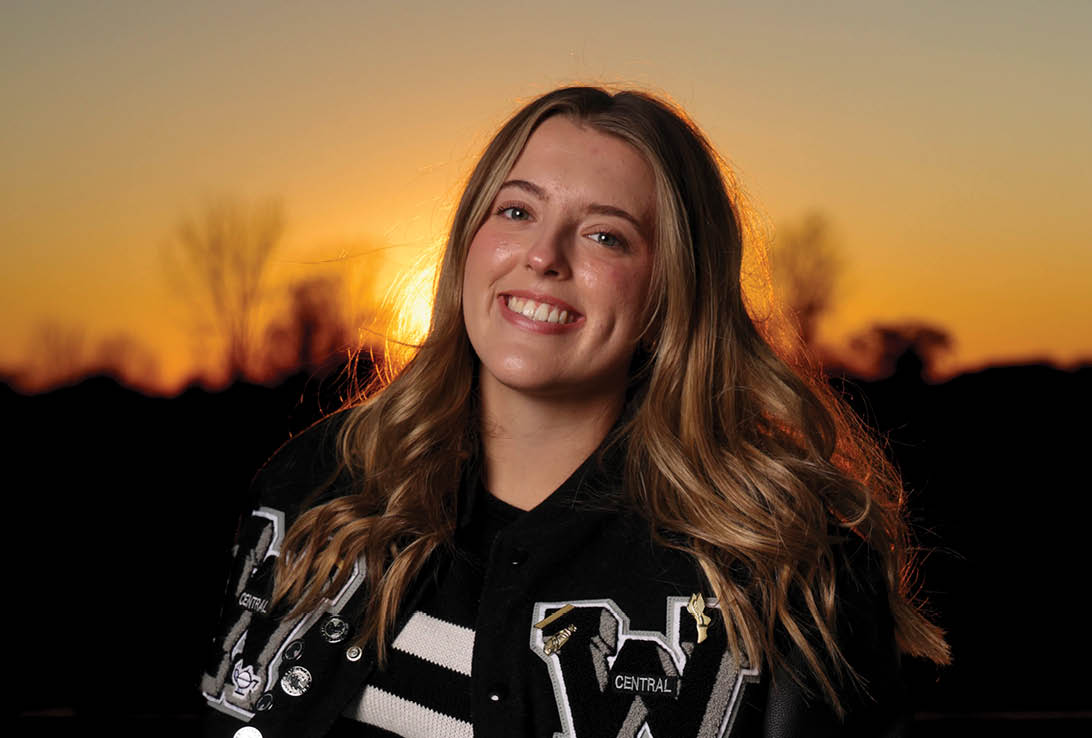 A woman wearing a black jacket with a white W on it. Description generated by AI