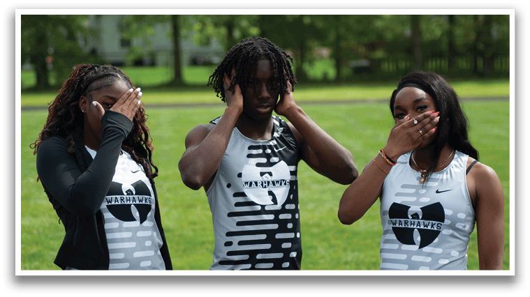 Three people standing in a grassy field. Description generated by AI