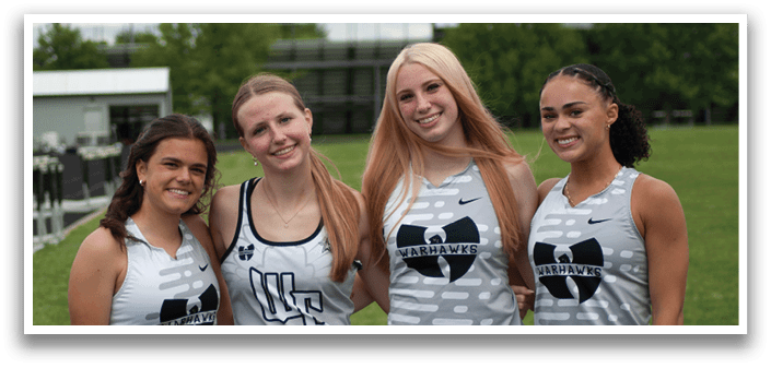 Four female athletes wearing grey and black uniforms. Description generated by AI