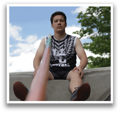 A man is sitting on a mat with his legs crossed. Description generated by AI