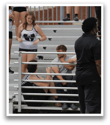 A group of people sitting on a bleacher. Description generated by AI