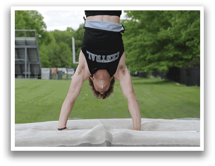 A man is doing a handstand on a mat. Description generated by AI