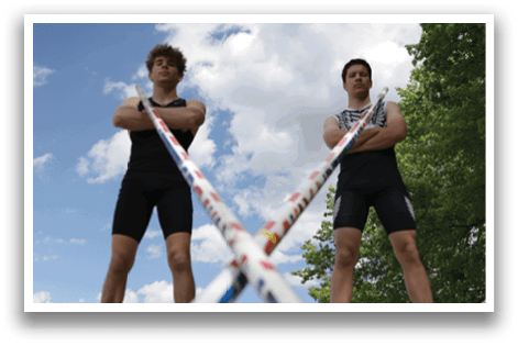 Two men standing in front of a red, white, and blue striped pole. Description generated by AI
