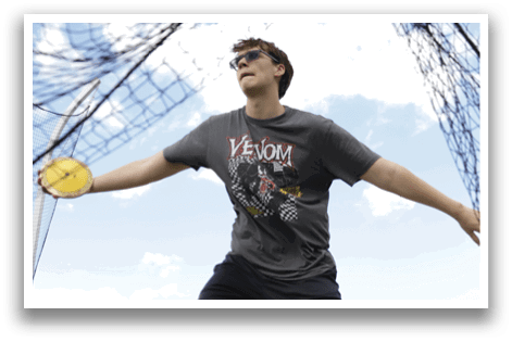 A man wearing a grey shirt and black shorts is throwing a frisbee. Description generated by AI