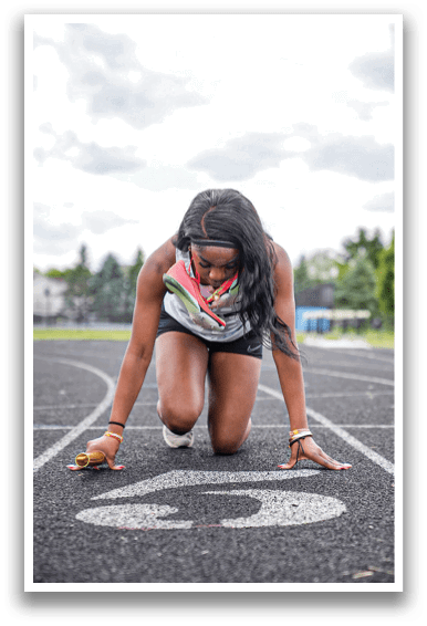 A woman is bending over on a track. Description generated by AI
