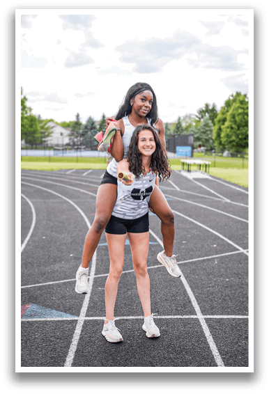 Two girls on a track. Description generated by AI