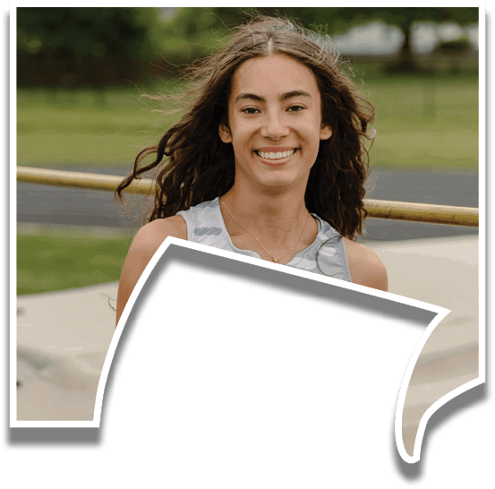 A woman wearing a grey and black shirt with a logo on it. Description generated by AI