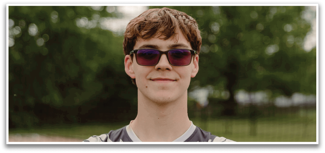 A man wearing sunglasses and a black and white shirt with a white bird on it. Description generated by AI