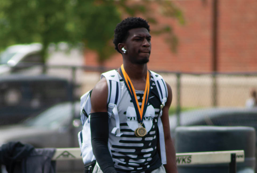 A man wearing a black and white shirt and a gold medal. Description generated by AI