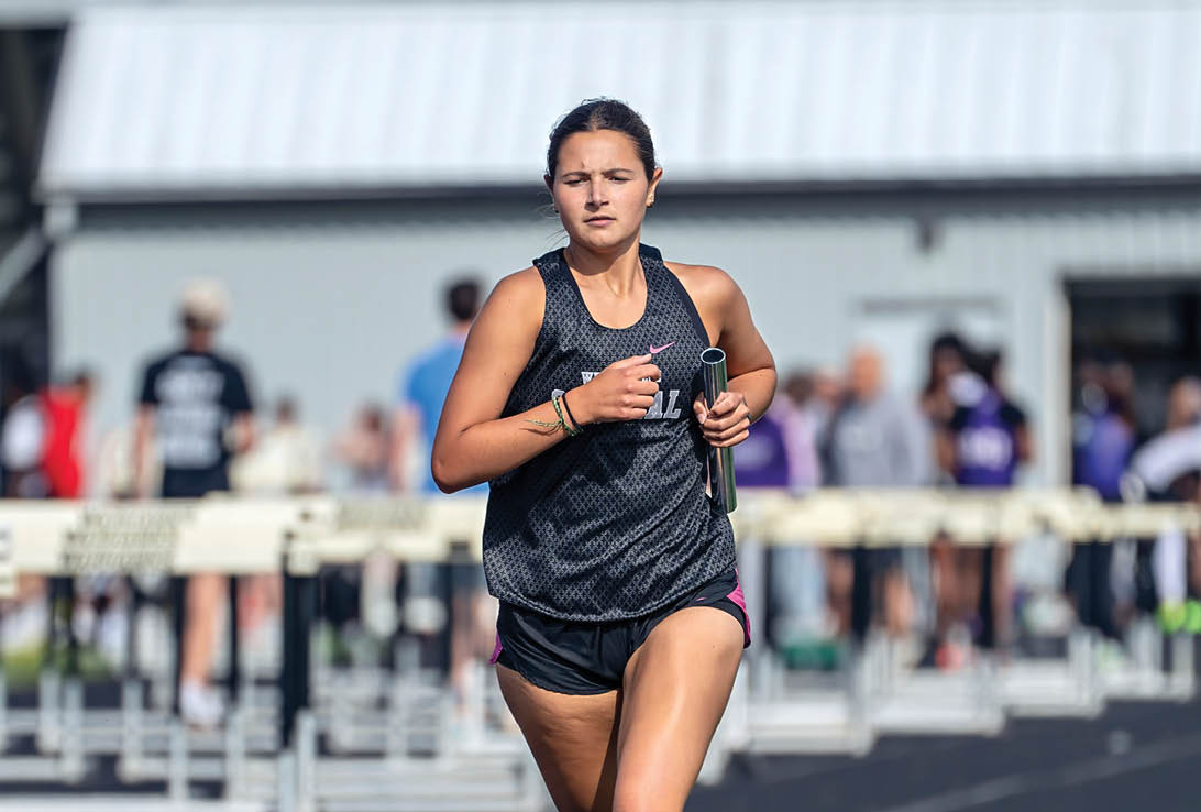 A woman running on a track. Description generated by AI