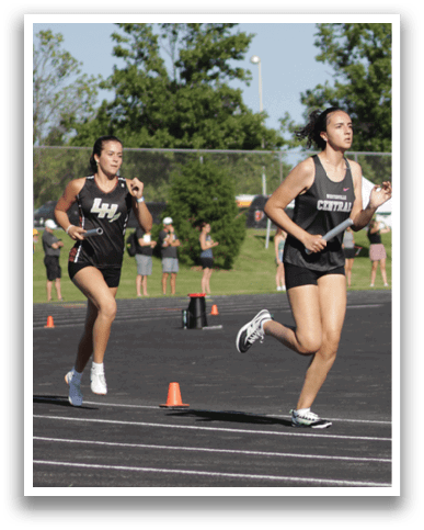 A group of people running on a track. Description generated by AI