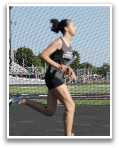 A woman running on a track. Description generated by AI