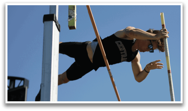 A man is on a horizontal bar, doing a handstand. Description generated by AI