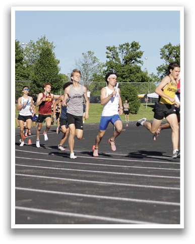 A group of people running on a track. Description generated by AI