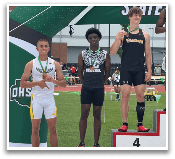 A boy is standing on a podium with two other boys. Description generated by AI