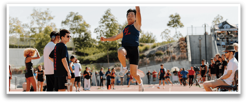 A man is jumping in the air on a track, possibly performing a high jump. AI generated content