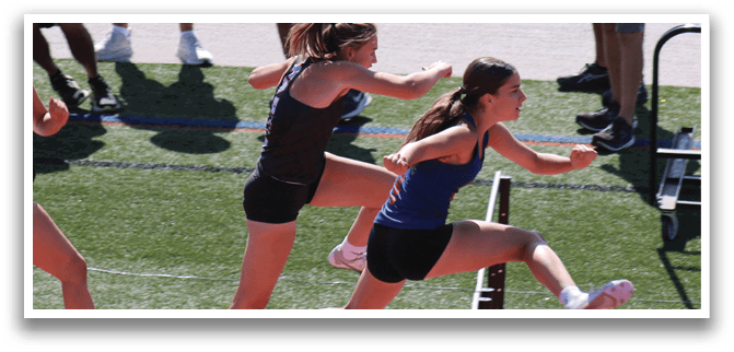 A woman is jumping over a barrier. Description generated by AI